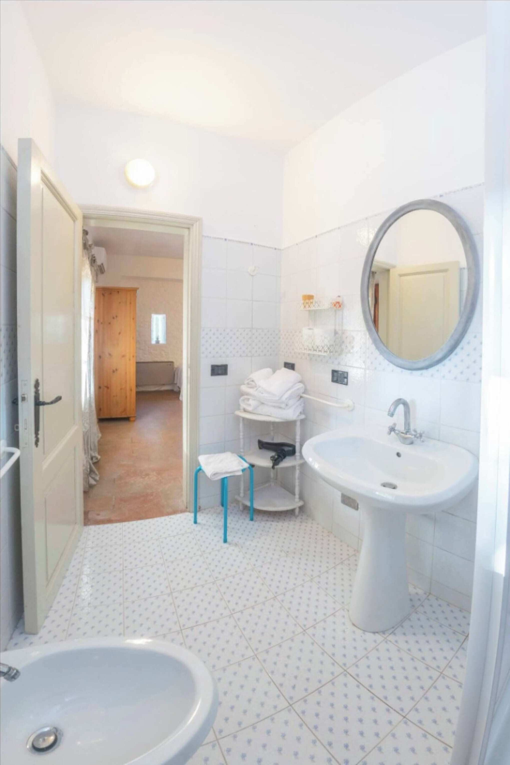 Ein Badezimmer mit Waschbecken, Spiegel und Toilette.