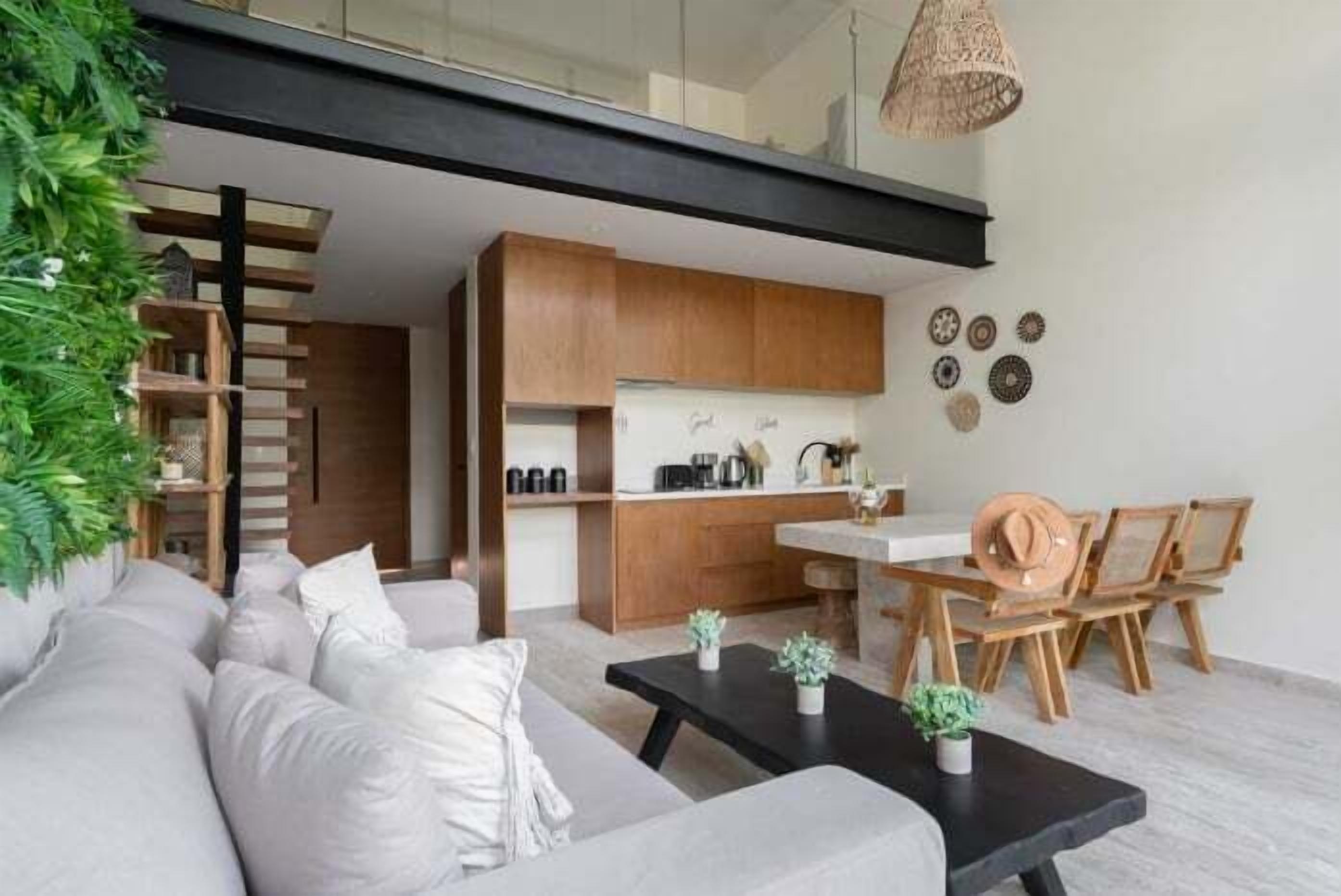 Un salon moderne avec un canapé, une table basse et un coin repas doté de chaises en bois.
