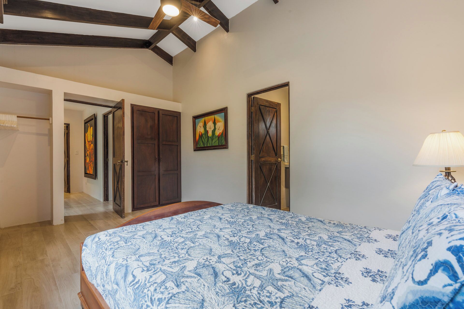 A bedroom with a bed, wooden wardrobe, and a door.