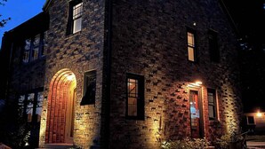 Un edificio de piedra con un amplio arco de entrada y una puerta principal iluminada.