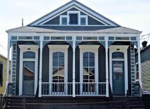 A two-story house with a gabled roof and a front porch with white trim. - Truly New Orleans Enjoyable 3-bedroom house with AC in welcoming New Orleans (New Orleans)