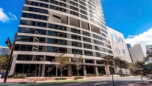 A modern building with a curved facade, large windows, and a sign indicating it is the UF District 225. - Maison 225 | Downtown Miami Luxe Retreat (Miami)