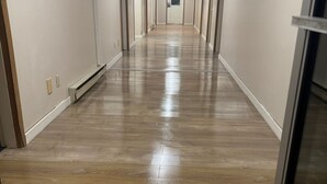 A long, narrow hallway with wooden flooring and white walls. - Barnays Motel (Letellier)