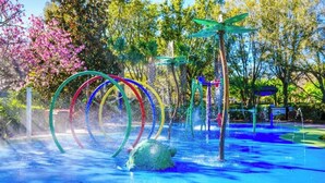 Ein Wasserspielbereich mit bunten Ringen und einer grünen Konstruktion.