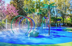 Ein Wasserspielbereich mit bunten Ringen und einer grünen Konstruktion.