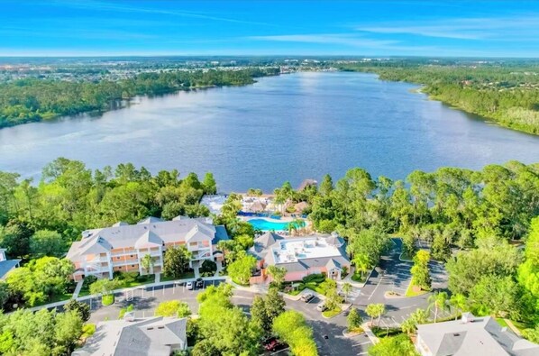 Ein Resort mit einem großen Schwimmbad, mehreren Gebäuden und Seeblick.