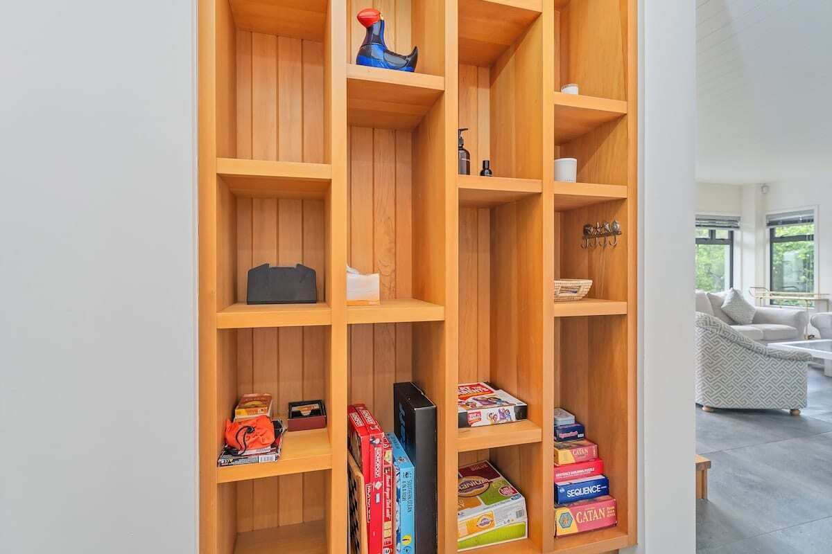 A wooden bookshelf with various items, including books and board games.