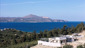 Una proprietà costiera con vista sul mare e una montagna sullo sfondo.