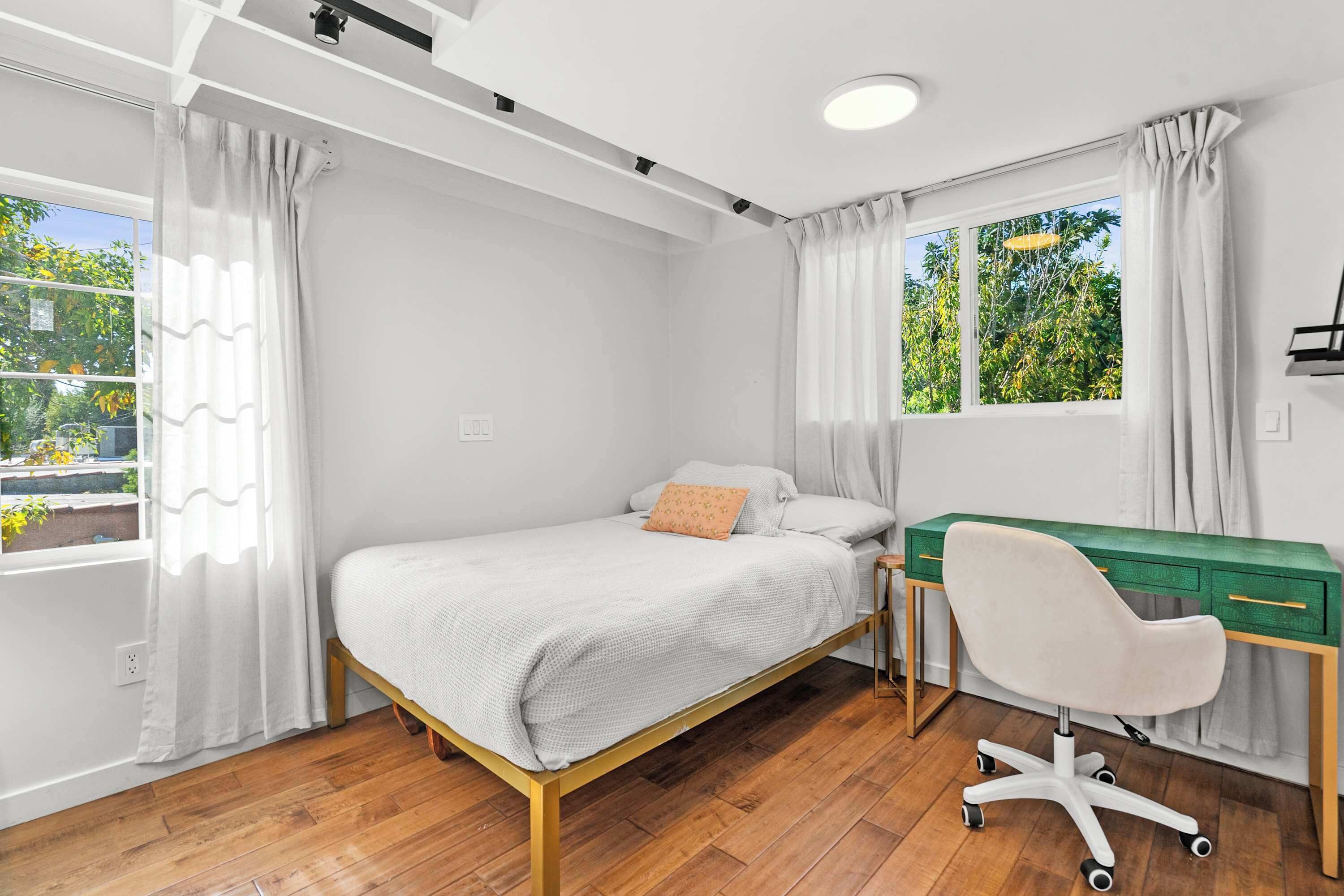 Une chambre à coucher avec un lit, un bureau et une chaise.