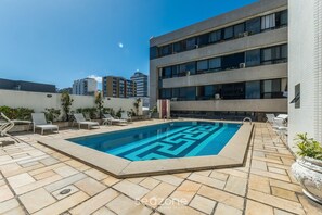 A rooftop swimming pool with a geometric pattern, surrounded by lounge chairs and potted plants. - Fully Equipped Apartments in a Building With Pool, 40 m From the Beach in Salvador Mpas (Salvador)