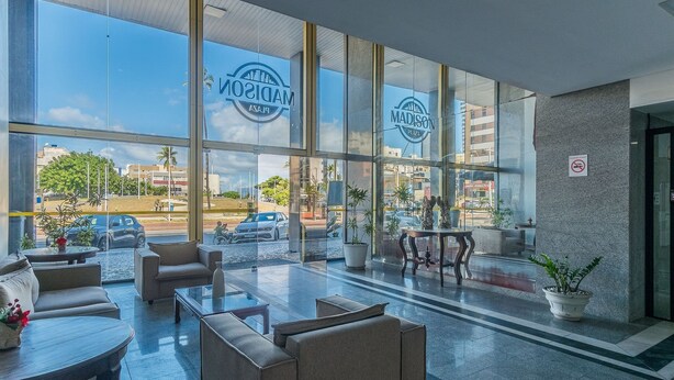 Un hall d’entrée moderne doté de grandes fenêtres, de sièges confortables et offrant une vue sur la rue.
