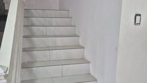 Un escalier recouvert de carreaux blancs et doté d’une rampe blanche.