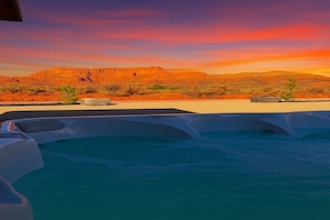 A pool with clear blue water, surrounded by desert landscape and mountains. - Modern Desert Cabin with Hot Tub & Sauna Access (Colorado City)