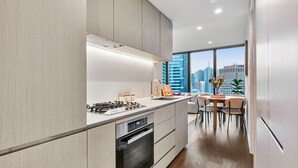 Una cocina moderna con estufa a gas, horno y zona de comedor con mesa y sillas.