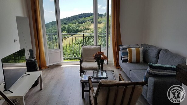A modern living room with a large window, a sofa, a chair, and a coffee table. - Gîte de Font Bénite 2 - SAINT-ANDRÉ-LA-CÔTE (SAINT-ANDRÉ-LA-CÔTE)