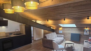 Eine moderne Küche mit eingebautem Geschirrspüler und einem Essbereich mit Holztisch und weißen Stühlen.