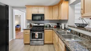 A modern kitchen with wooden cabinets, stainless steel appliances, granite countertops, and a double sink. - Red Door Cottage | 1/2 Mile to Whiskey Row (Prescott)