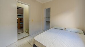 A bedroom with a bed, a closet, and a bathroom door. - Sua Casa na Enseada Perto da Praia e de Tudo (Guarujá)