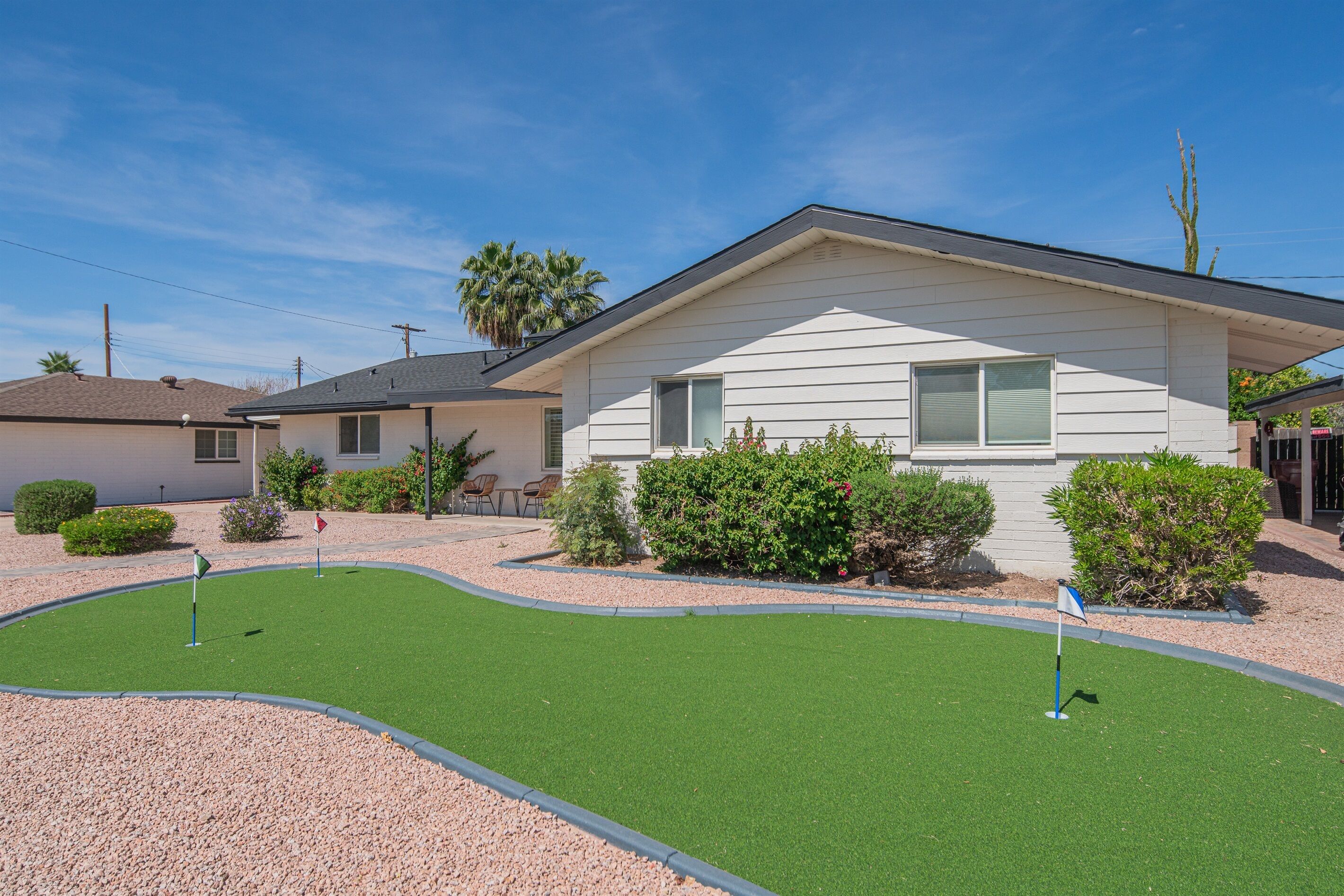 A residential property with a well-maintained lawn, a small patio area, and a house with a gabled roof.
