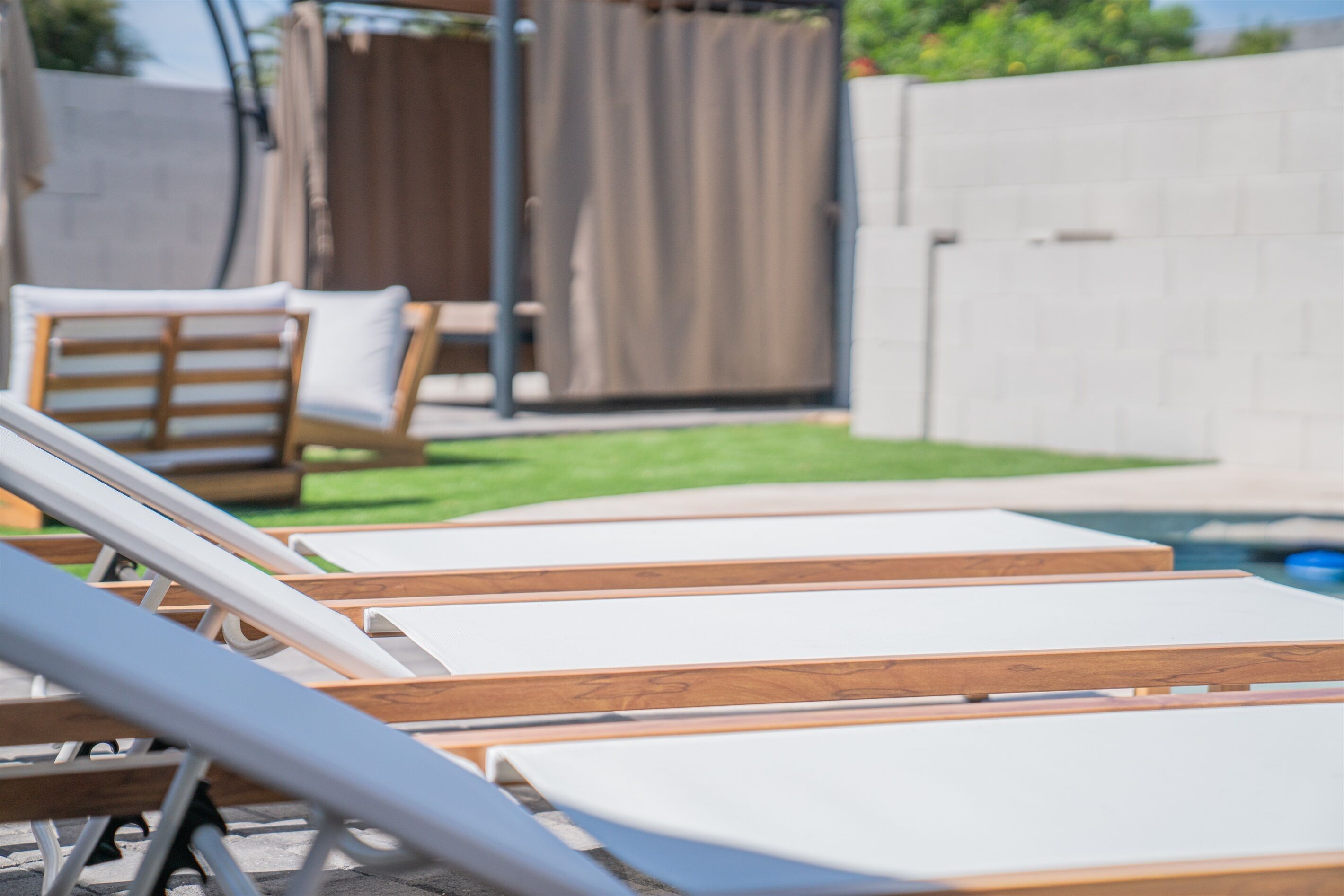Un espace aménagé au bord de la piscine, avec des chaises longues et une petite piscine.