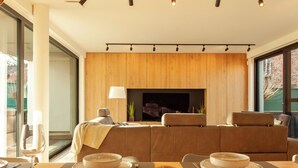 A modern living room with a sofa set, a fireplace, and a dining area with table set for two. - 8P 4B Luxury Villa Close to Maastricht (Lanaken)