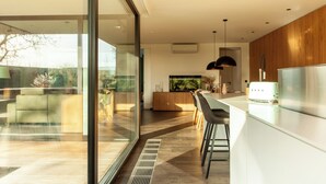 A modern kitchen with a large island, a built-in oven, and a stainless steel refrigerator. - 8P 4B Luxury Villa Close to Maastricht (Lanaken)