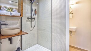 A modern bathroom with a large mirror, a round sink, a shower with a handheld showerhead, and a towel rack with folded towels. - Panoramic terrace apartment 200 meters from the lake 2 terraces (Talloires-Montmin)