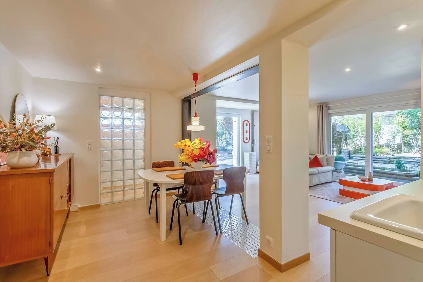 Una cocina moderna con comedor, armarios de madera y vistas al exterior.