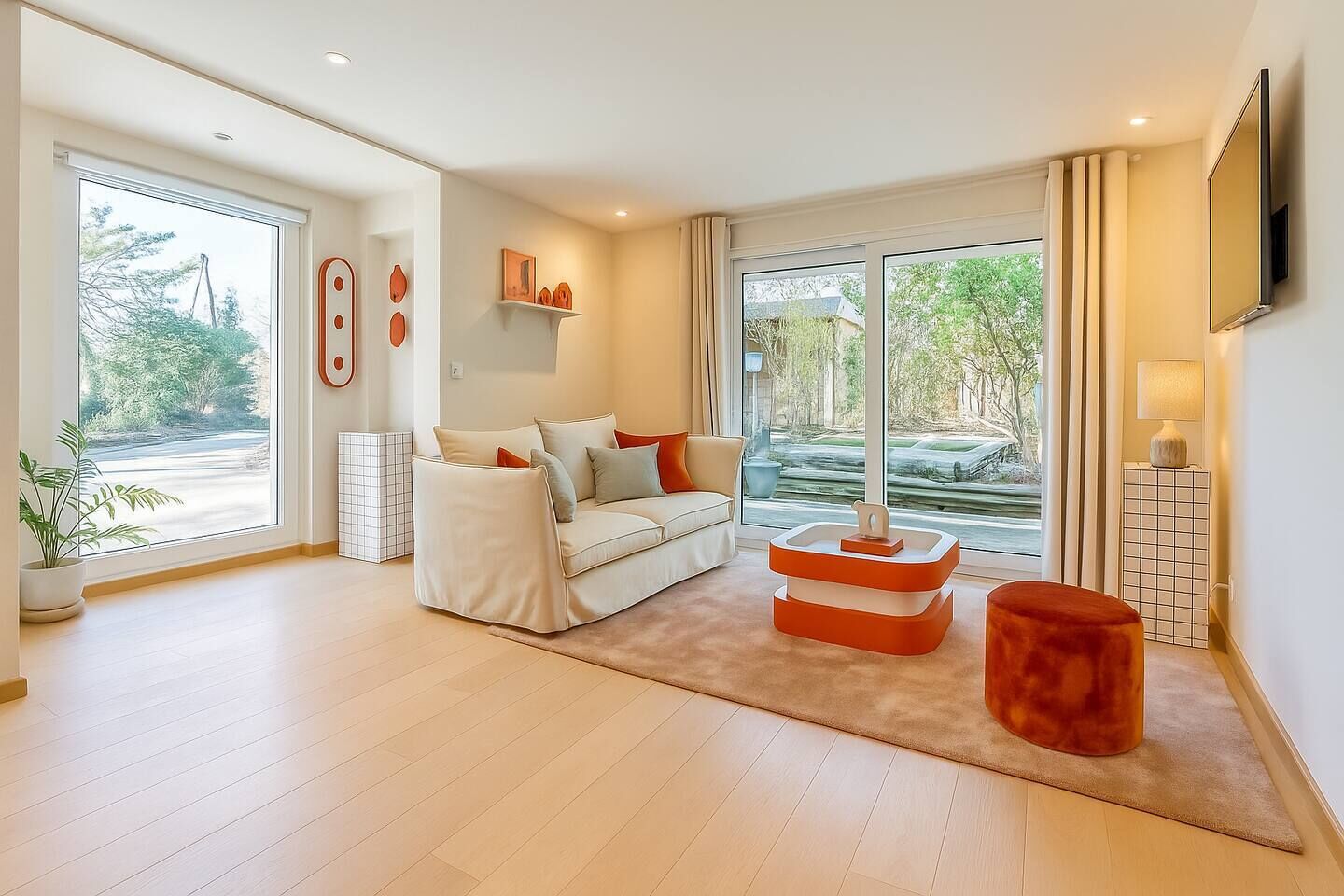 Una sala de estar moderna con un sofá, una mesa de centro y un televisor montado en la pared.