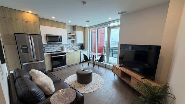 A modern apartment with a kitchen, dining area, and living room. - Waterfront 1 BR with 6 appliances and huge patio (Halifax)