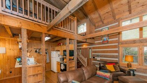 A cabin interior with a wooden interior, a kitchen area, a sofa, and a dining table. - 3 Brothers Rustic Sabbatical Creekside Cabin (Walland)