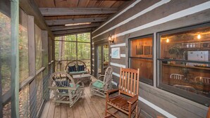 A wooden porch with wicker furniture, a table, and chairs. - 3 Brothers Rustic Sabbatical Creekside Cabin (Walland)