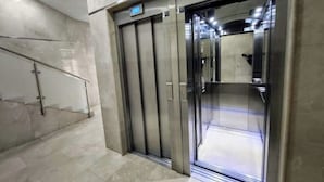 Een moderne lift met metalen deuren en een digitaal scherm.