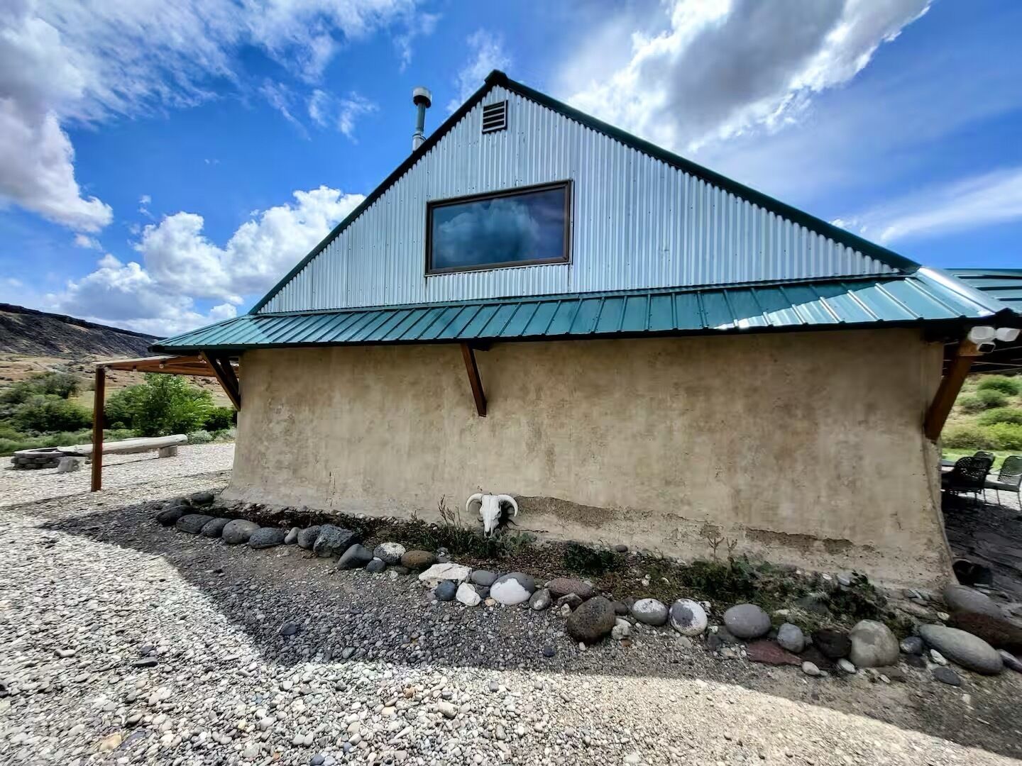 A small, single-story building with a metal roof and a window.