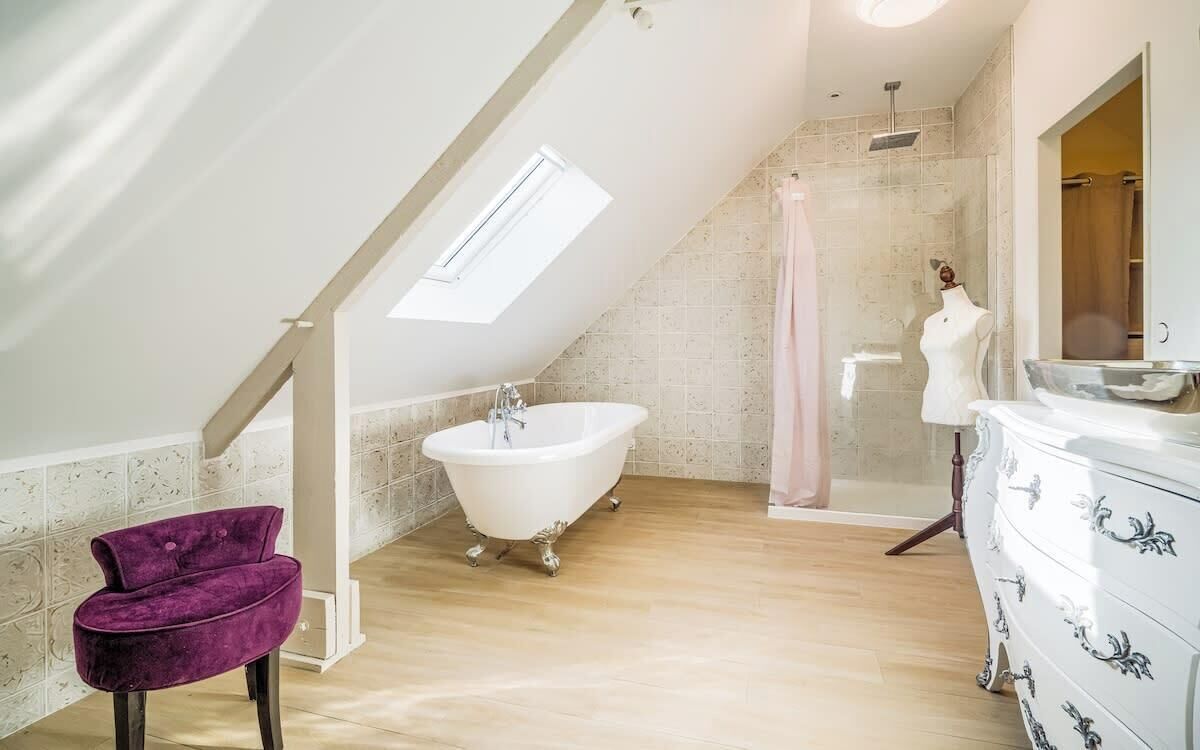 Un baño moderno con una bañera independiente, un tocador con espejo y una zona de ducha.