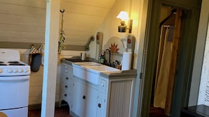 A kitchen with a stove, sink, and cabinets.