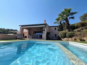 A swimming pool with a patio area, a covered outdoor seating space, and a palm tree. - Seaview Villa with Heated Pool & Balneotherapy - 10' walk to beach -5 BR- Air Co (Saint-Raphaël)