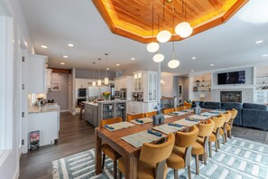 Une cuisine moderne avec des meubles blancs, un îlot central et des luminaires suspendus.