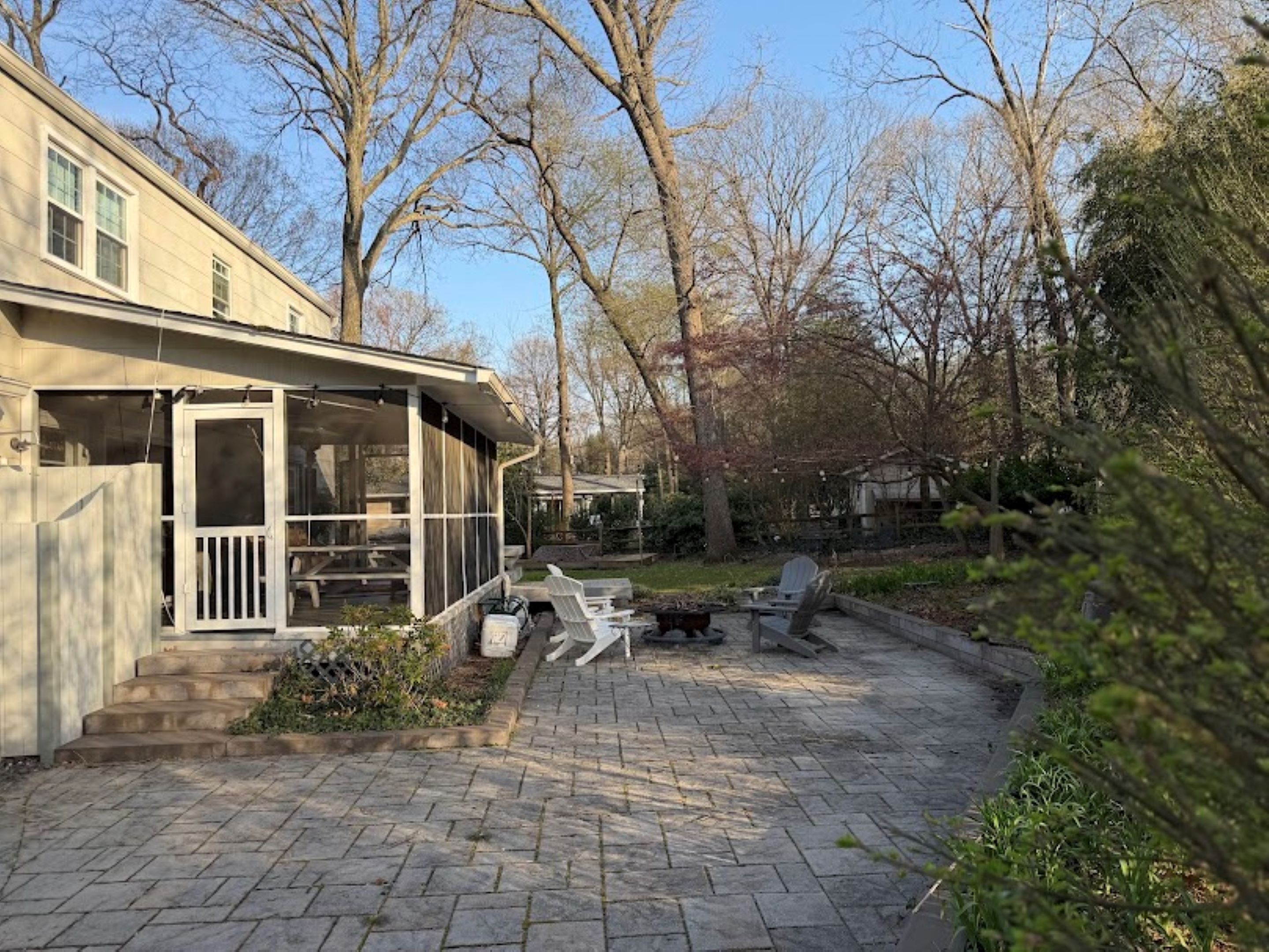 Une maison dotée d’un patio couvert, d’un espace salon extérieur et d’un jardin.