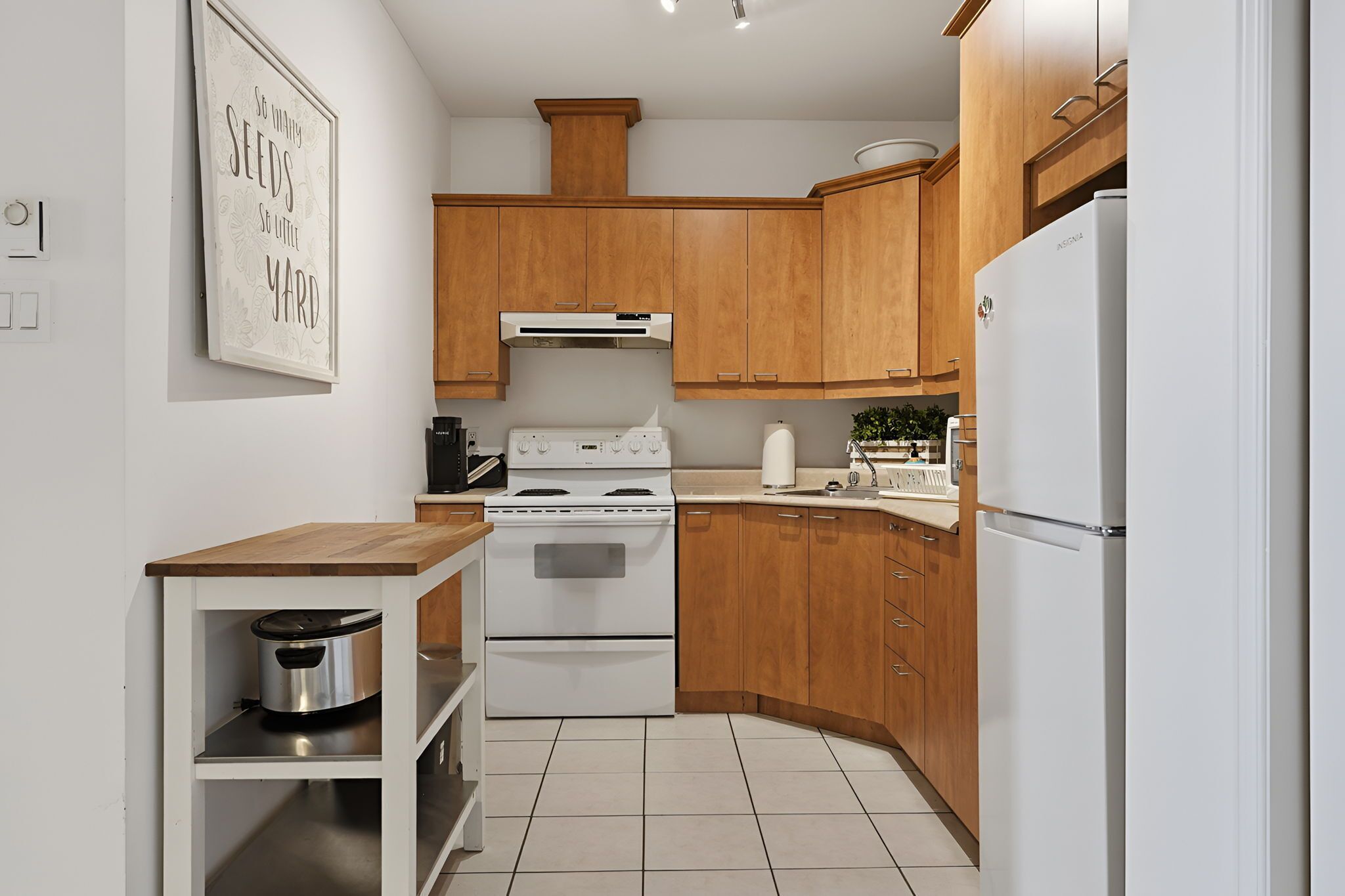 Une cuisine moderne avec des meubles en bois, une cuisinière blanche et un réfrigérateur blanc.