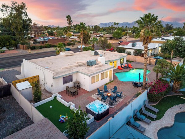 A residential area with a swimming pool, patio furniture, and a hot tub. - Refreshing Pool • Hot Tub • Game Room • Sleeps 11 (Scottsdale)