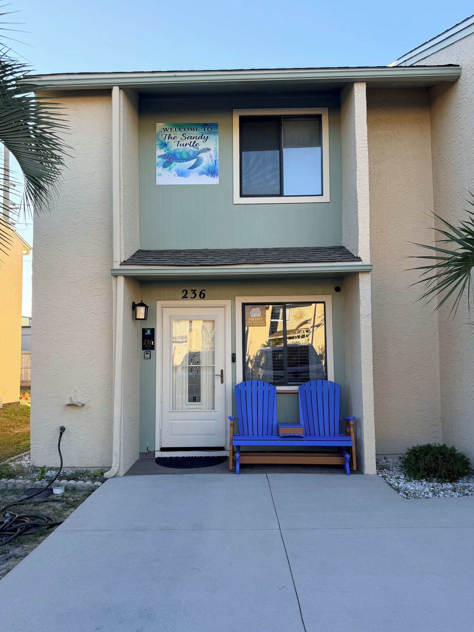A two-story building with a sign welcoming visitors to 'The Sandy Turtle.'