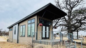 A small, single-story building with a sloped roof, large windows, and a small porch area. - Little Luxe Hideaway with Pool & Hot Tub (Austin)