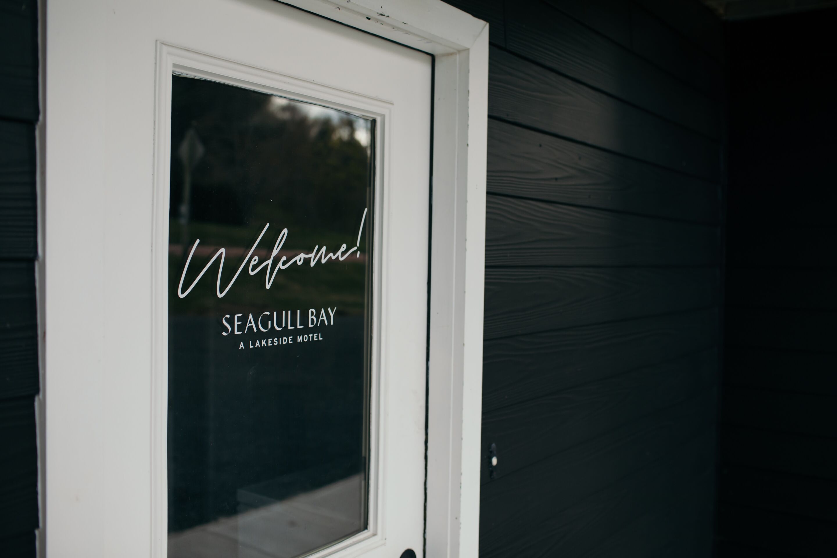 A window with a welcome message and the name "Seagull Bay" indicating a lakeside motel.