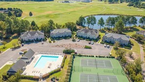 Vista aèria d'un camp de golf amb piscina, pistes de tennis i edificis residencials.