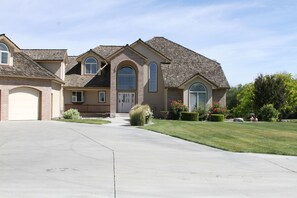 A two-story house with a garage, a front porch, and a well-maintained lawn. - Mansion, pool, hot tub, 3 acres, private (Ontario)