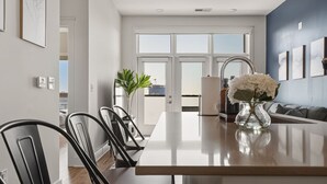 Une cuisine moderne avec un îlot central, des chaises de salle à manger et un vase de fleurs.