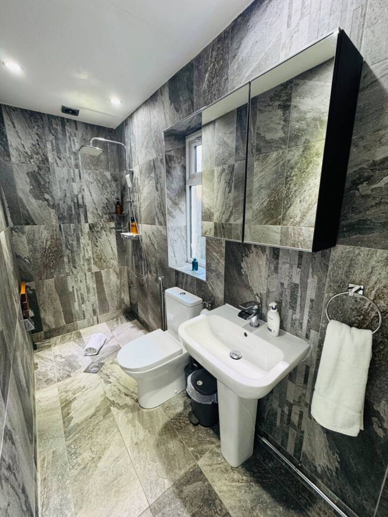 Een douche, handdoeken, zeep, toiletpapier