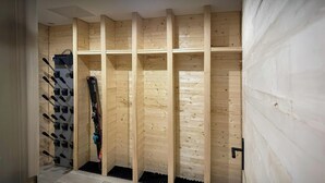 L’intérieur d’un chalet en bois, avec un porte-skis, une cheminée et un plancher en bois.