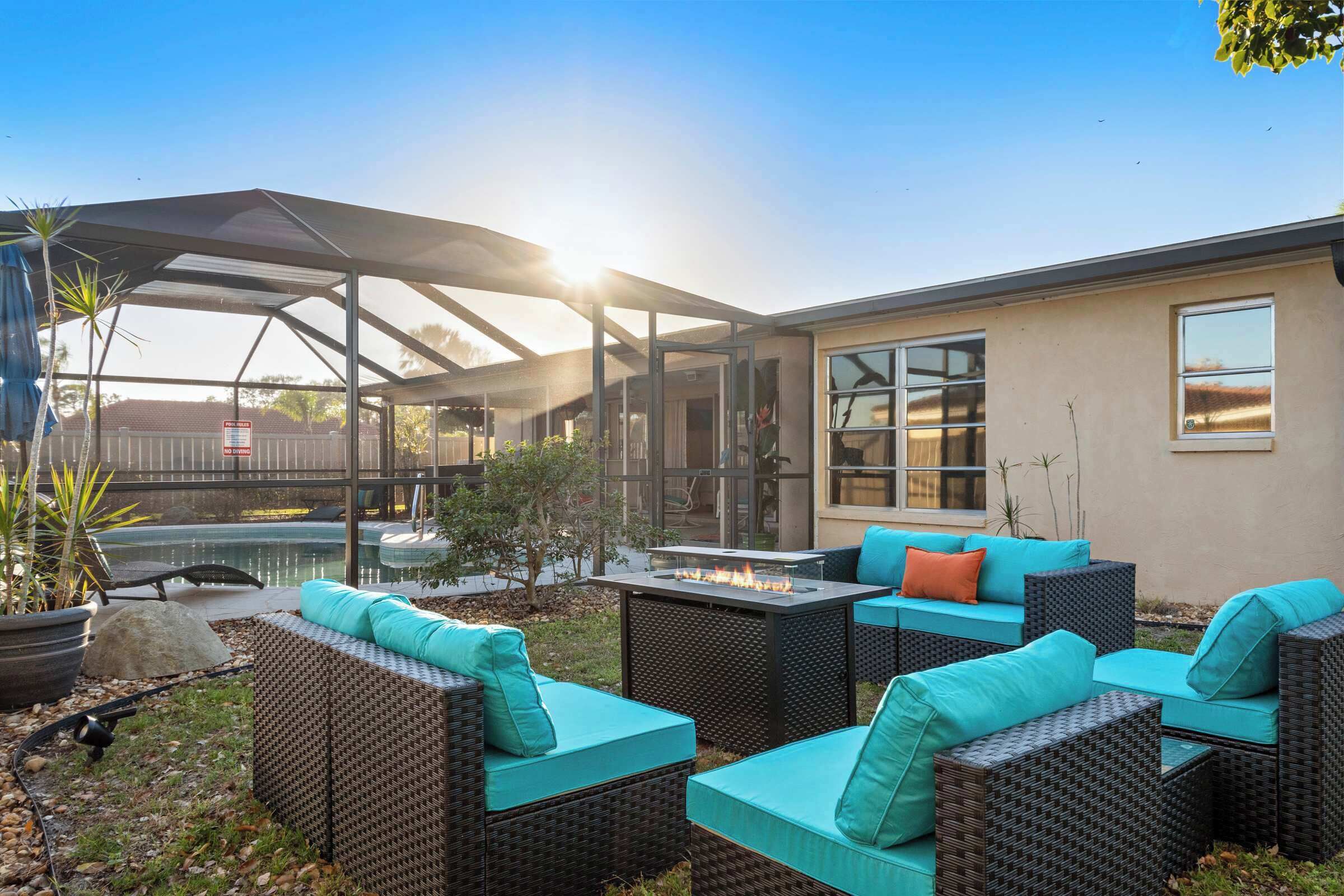Une terrasse extérieure avec des meubles en osier et un foyer.